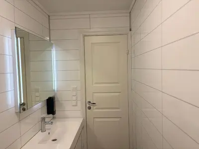 a white bathroom with a sink and a mirror at Brekke Apartments in Flåm