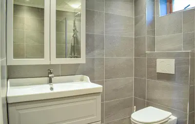 a bathroom with a white sink and a toilet at 4 Bedroom Lovely Home In Strandebarm in Strandebarm