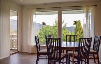 a dining room with a table and chairs and a window at 4 Bedroom Lovely Home In Strandebarm in Strandebarm