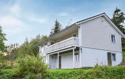 a white house with a balcony on top of it at 4 Bedroom Lovely Home In Strandebarm in Strandebarm