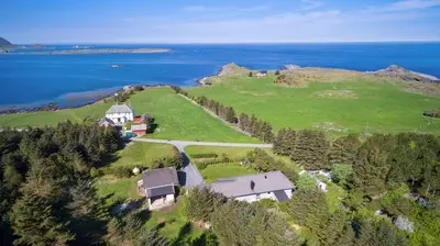 an aerial view of a house on a hill next to the ocean at Flemsøy in Ålesund