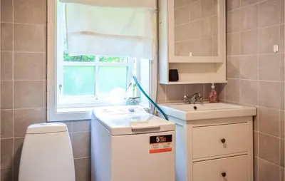 a small bathroom with a sink and a window at 2 Bedroom Cozy Home In Vallavik in Kaland