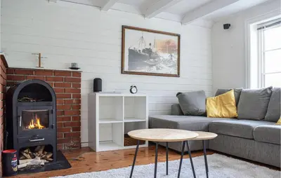 a living room with a couch and a fireplace at 2 Bedroom Cozy Home In Vallavik in Kaland