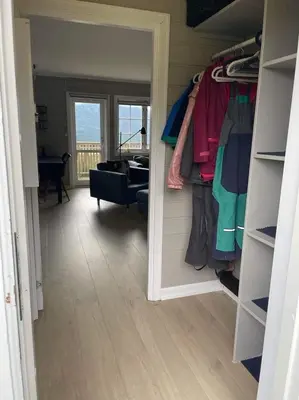 a walk in closet with a view of a living room at Privat apartment with beautiful view and two bedrooms in Oppdal