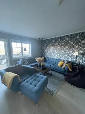 a living room with a blue couch and a table at Privat apartment with beautiful view and two bedrooms in Oppdal