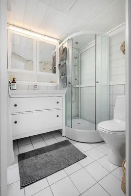 a white bathroom with a shower and a toilet at Økslevegen 2 in Stranda