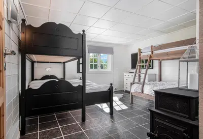 a bedroom with two bunk beds and a fireplace at Økslevegen 2 in Stranda
