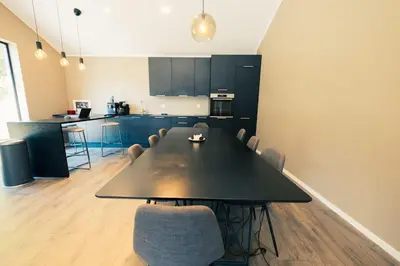 a kitchen with a large black table and chairs at Modalen Fjord Cottage in Mo