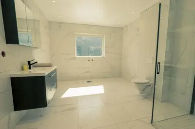 a bathroom with a shower and a sink and a toilet at Modalen Fjord Cottage in Mo
