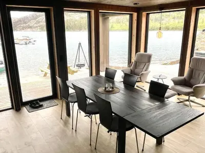 a dining room with a large wooden table and chairs at 7 person holiday home in Huglo-By Traum in Nordhuglo