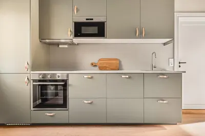 a kitchen with grey cabinets and a microwave at Odda Panorama in Odda