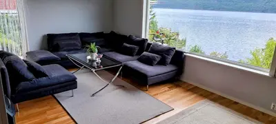 a living room with a couch and a large window at Bergen Sunrise Terrace Apartment in Bergen