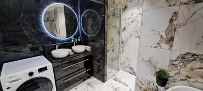 a bathroom with a washing machine and a mirror at Bergen Sunrise Terrace Apartment in Bergen