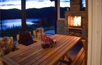 a wooden table in a room with a fireplace at Lovely Home In Hjartdal With Sauna in Hjartdal