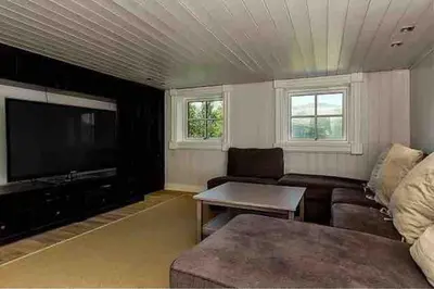 a living room with a couch and a flat screen tv at Stor og eksklusiv tømmerhytte Hemsedal in Grøndalen