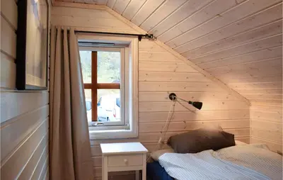 a small bedroom with a bed and a window at Cozy Home In Norheimsund With Sauna in Norheimsund