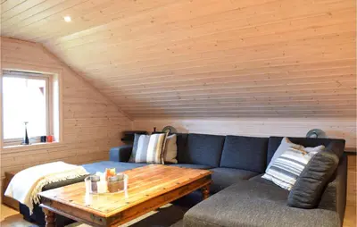 a living room with a blue couch and a wooden table at Cozy Home In Norheimsund With Sauna in Norheimsund