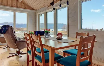 a dining room with a table and chairs and windows at Pet Friendly Home In Roan in Moen