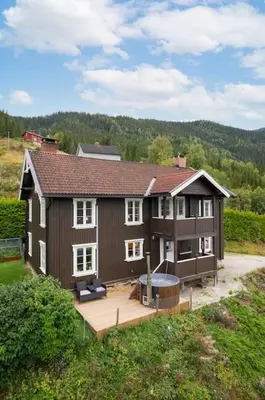 a large house with a hot tub in the yard at Stamp and sauna! Small farm with fantastic view! in Favang