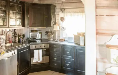 a kitchen with dark wood cabinets and a sink at Stunning Home In Søre Osen in Midskogberget