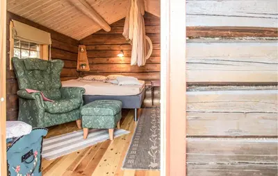 a bedroom with a bed and a chair in a cabin at Stunning Home In Søre Osen in Midskogberget