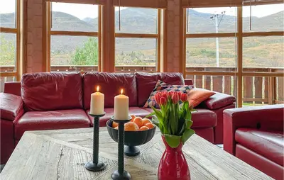 a living room with a couch and a table with candles at Cozy Home In Straumgjerde With Sauna in Brunstad