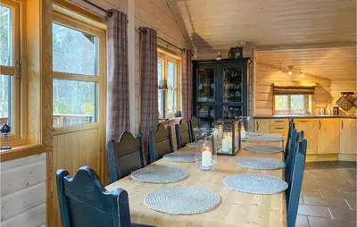 a dining room with a long table and chairs at Cozy Home In Straumgjerde With Sauna in Brunstad