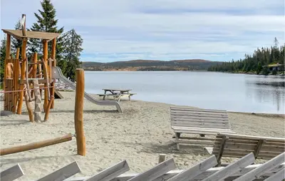 two benches and a playground on a beach at Stunning Home In Sjusjøen With Sauna in Sjusjøen