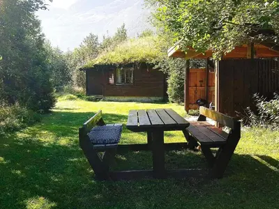 a picnic table and a bench in the grass at 4 person holiday home in Oldedalen-By Traum in Briksdalsbre