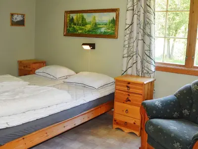 a bedroom with a bed and a chair and a window at 4 person holiday home in Oldedalen-By Traum in Briksdalsbre