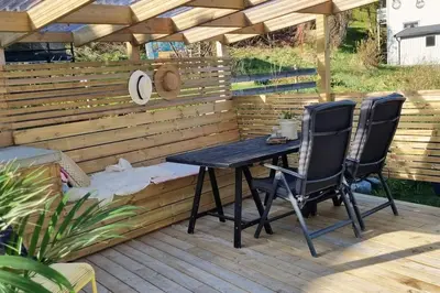 a patio with a table and two chairs on a deck at The Fjord House in Snofugl