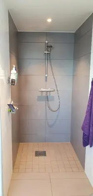 a bathroom with a shower with a glass door at The Fjord House in Snofugl