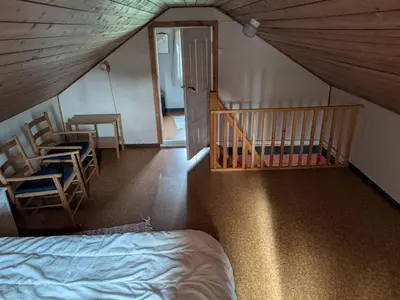 a bedroom with a bed and two chairs and a staircase at 4 person holiday home in HARDBAKKE-By Traum in Hardbakke