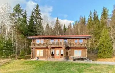 a large log house with a deck in the woods at 5 Bedroom Gorgeous Home In Eggedal in Eggedal