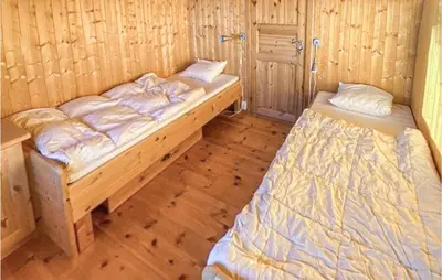two beds in a room with wooden floors at 5 Bedroom Gorgeous Home In Eggedal in Eggedal