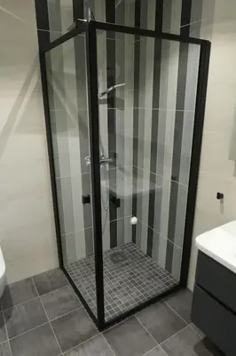 a shower with a glass door in a bathroom at Moderne panoramaleilighet 3-roms i Olden in Olden