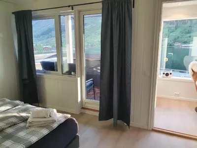 a bedroom with a bed and a large window at Moderne panoramaleilighet 3-roms i Olden in Olden