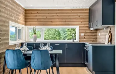 a kitchen with a table and blue chairs at Stunning Home In Gjemnes With Wifi in Stokke
