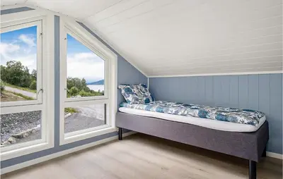 a bed sitting in a room with two windows at Stunning Home In Gjemnes With Wifi in Stokke