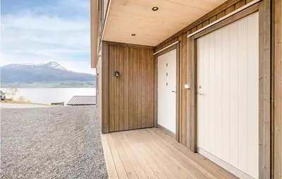 a house with two garage doors and a mountain at Stunning Home In Gjemnes With Wifi in Stokke