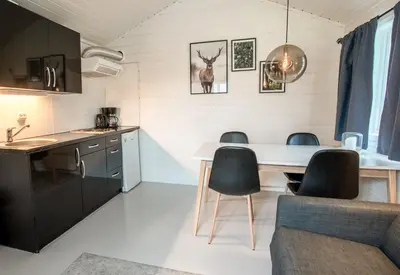 a kitchen and living room with a table and chairs at Koie Family in Stranda