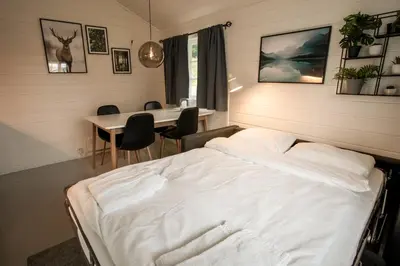 a bedroom with a bed and a table with chairs at Koie Family in Stranda