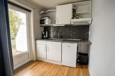 a kitchen with white cabinets and a large window at Koie Standard in Stranda