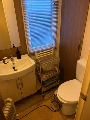 a bathroom with a sink and a toilet and a window at Koie Holiday Home 3 in Stranda