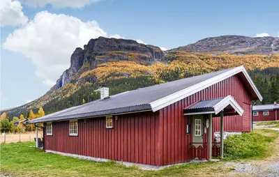 a red barn with a mountain in the background at Gorgeous Home In Hemsedal With Sauna in Hemsedal