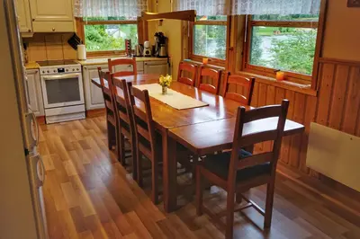a kitchen with a wooden dining room table and chairs at Fully equipped cabin by the fjord in Volda