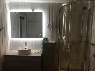 a bathroom with a sink and a shower and a mirror at Stor familiehytte på Småsætra, Sjusjøen in Sjusjøen