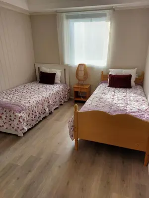 a bedroom with two beds and a window at peaceful place in Hønefoss