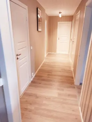 a hallway with white doors and wood floors at peaceful place in Hønefoss