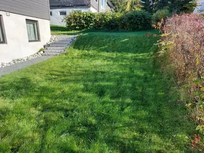 a yard with green grass next to a house at peaceful place in Hønefoss